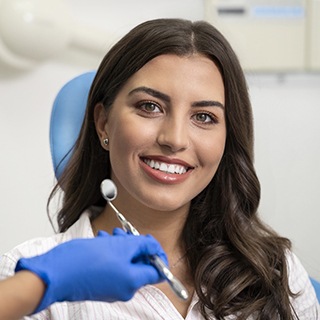 Brunette woman smiling in dental chair