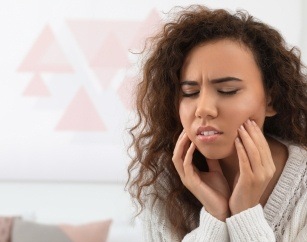 Woman in pain holding jaw joints
