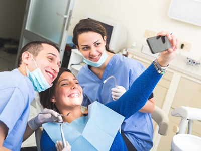 Woman taking selfie with dental team