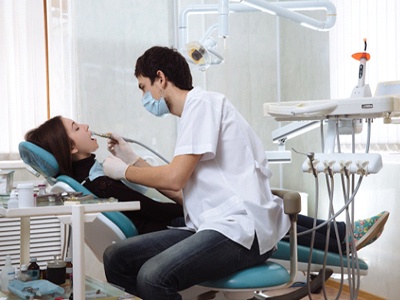 Dentist performing dental treatment on woman