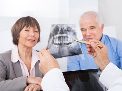An older couple examining an x ray of teeth during a dental checkup
