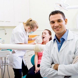 A pair of dentists performing an exam on a patient