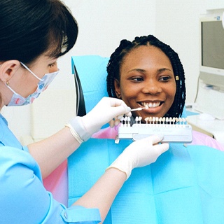 Dentist using shade guide on patient