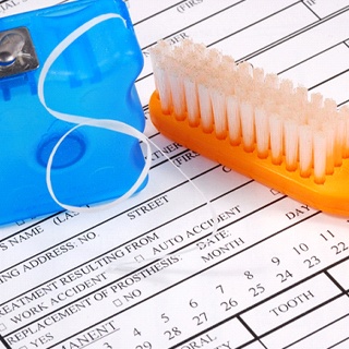 Toothbrush and floss on dental insurance form