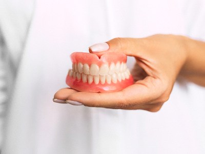 Dentist holding full dentures in Pembroke Pines