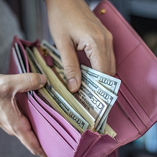 Woman holding wallet of money