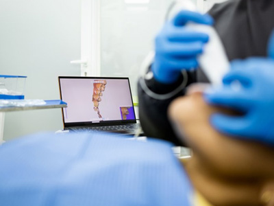 Dentist using an intraoral camera while patient’s teeth appear on a monitor 