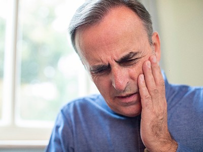 Man with tooth pain who needs an emergency dentist in Pembroke Pines