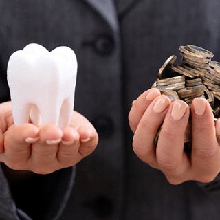 Woman holding tooth and coins in hands