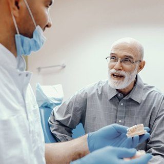 An older patient asking his dentist about implant dentures