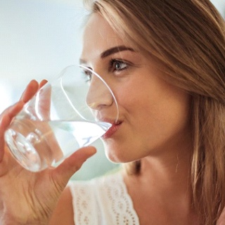 woman drinking water from a glass