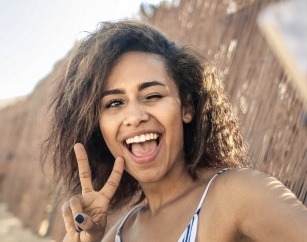 Smiling woman giving peace sign