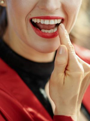 Woman examining her smile in the mirror