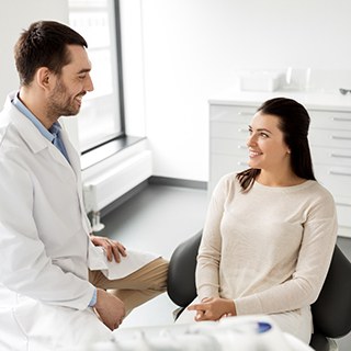 Woman in dental chair smiling at her dentist