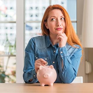 Woman putting coin in piggy bank