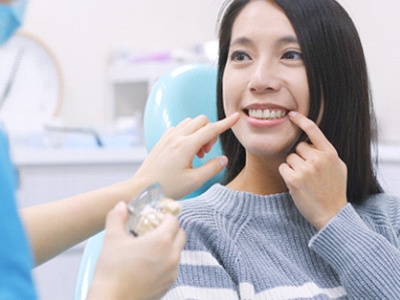 Woman at dentist pointing to her tooth