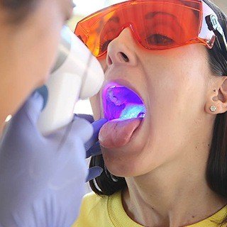 Dentist performing oral cancer screening