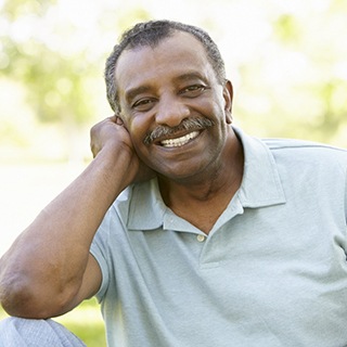 person smiling while sitting in a park