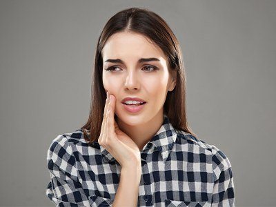 Woman holding cheek in pain