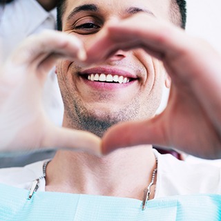 Patient and dentist making heart with hands