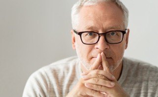 Older man covering his mouth