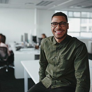person sitting on a desk and smiling