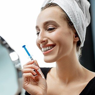 person wearing their teeth whitening trays in the bathroom