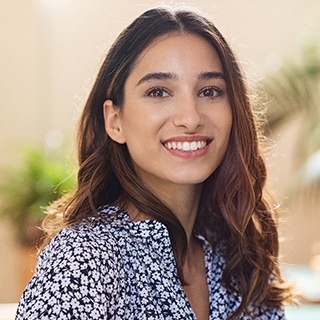 Young woman in patterned shirt smiling with veneers